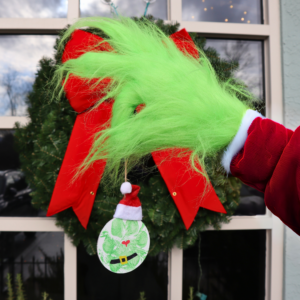 Grinch hand holding an ornament